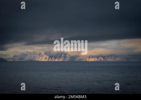 Die bergige Küste von Bylot Island in Nunavut, Kanada, ist teilweise von Wolken verdeckt. Stockfoto