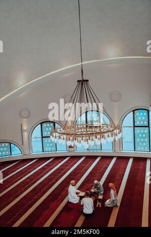 Eine Gruppe von Muslimen, die das heilige Buch des Korans während des muslimischen Feiertags von Ramadan in einer modernen Moschee las Stockfoto