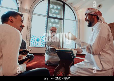 Eine Gruppe von Muslimen, die das heilige Buch des Korans während des muslimischen Feiertags von Ramadan in einer modernen Moschee las Stockfoto