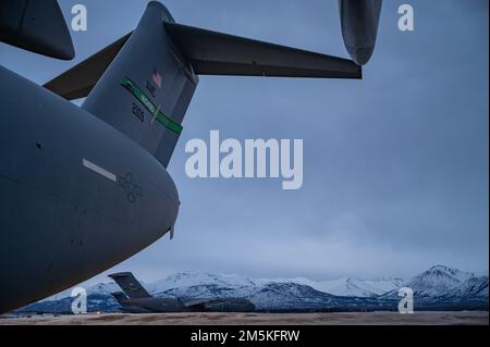 Drei C-17-Globemaster Il, die der Joint Base Lewis-McChord, Washington, zugewiesen sind, bereiten sich auf den Start von einer Startbahn während der Übung Rainer war 22A vor, auf der Joint Base Elmendorf-Richardson, Alaska, 22. März 2022. Die Übung soll die Fähigkeit des 62. Airlift Wing demonstrieren, zu operieren und zu überleben und gleichzeitig Herausforderungen für den militärischen Vorteil der USA in allen Betriebsbereichen – Luft, Land, See und Cyberspace – zu meistern. Stockfoto