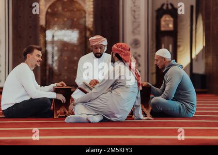 Eine Gruppe von Muslimen, die das heilige Buch des Korans während des muslimischen Feiertags von Ramadan in einer modernen Moschee las Stockfoto