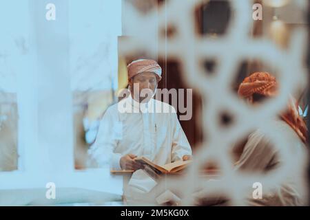Eine Gruppe von Muslimen, die das heilige Buch des Korans während des muslimischen Feiertags von Ramadan in einer modernen Moschee las Stockfoto