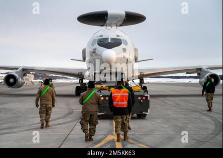 USA Die der 962. Aircraft Maintenance Unit zugeteilten Luftfahrzeuginstandhaltungseinheit überwachen ein E-3 Sentry Airborne Warning and Control System, während das Luftfahrzeug auf der gemeinsamen Basis Elmendorf-Richardson, Alaska, am 22. März 2022 abgeschleppt wird. Das Flugzeug liefert dem Joint Air Operations Center ein genaues Echtzeitbild des Kampfraums. AWACS bietet Situationsbewusstsein für freundliche, neutrale und feindliche Aktivitäten, Kommando und Kontrolle über ein Verantwortungsgebiet, Kampfmanagement der Theatertruppen, Überwachung des Kampfraums in allen Höhen und bei jedem Wetter und Frühwarnung vor feindlichen Aktionen während gemeinsamer, alliierter, an Stockfoto