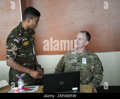 USA Army Captain Dean Hill, Delegierter und Logistikoffizier der Oregon National Guard, spricht mit seinem Amtskollegen in Bangladesch, während er am 23. März 2022 im Bangladesch Institute of Peace Support Operation Training (BIPSOT) in Dhaka, Bangladesch, teilnahm. Delegierte der Oregon National Guard nehmen an der Übung Tiger Lightning 2022 Teil, einer bilateralen Übung, die von den USA gesponsert wird Das Kommando Indo-Pacific und Gastgeber der Streitkräfte Bangladeschs, Stärkung der Verteidigungsbereitschaft Bangladeschs, Aufbau operativer Interoperabilität und Stärkung der Partnerschaft zwischen den Streitkräften Bangladeschs und der Stockfoto