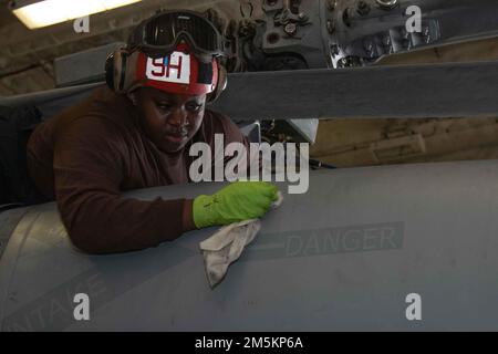 Aviation Machinist's Mate 3. Class Diandra Johnson, aus Bridgeport, Kentucky, dem „Tridents“ des Helicopter Sea Combat Squadron (HSC) 9 zugeteilt, reinigt einen MH-60s Nighthawk, dem HSC 9 angehängt, in der Hangarbucht von USS Gerald R. Ford (CVN 78), 23. März 2022. Ford führt im Atlantik im Rahmen der auf das Schiff zugeschnittenen Grundphase vor dem Einsatz die Zertifizierung von Cockpits und die Qualifikation von Luftfahrtunternehmen durch. Stockfoto