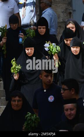 Orthodoxe christliche Nonnen, die in einer Prozession vom Grab der Jungfernkapelle zur Grabeskirche des Heiligen Grabes in Jerusalem spazieren. Stockfoto