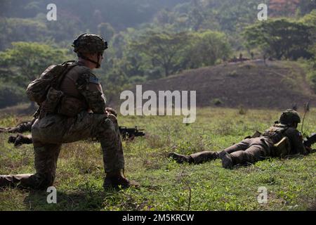 USA Army 1. LT. Jamal Husien von Kompanie D, 2. Bataillon, 27. Infanterie-Regiment, 3. Brigaden-Kampfteam, 25. Infanterie-Division, beobachtet eine Gruppe philippinischer Soldaten, die dem 1. Brigaden-Kampfteam zugeteilt sind, Auf ihre Ziele während einer kombinierten Feuerübung zur Unterstützung von Salaknib auf dem Luftwaffenstützpunkt Oberst Ernesto Rabina auf den Philippinen, 23. März 2022. Salaknib wird jährlich von der philippinischen Armee in den USA geführt Von der Army Pacific gesponserte bilaterale Übung zur Verbesserung der Kapazitäten und der Interoperabilität der US-amerikanischen und der philippinischen Armee im gesamten Spektrum militärischer Operationen, aber auch stren Stockfoto