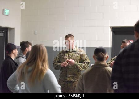 Ein Soldat der Nationalgarde von Michigan bespricht Militärfahrzeuge mit High-School-Schülern während eines Meet the Guard Events, Jackson Readiness Center, Jackson, Michigan, 23. März, 2022. Die Armeekammer der Michigan Army National Guard öffnete der Gemeinde ihre Türen, um einige ihrer Fähigkeiten zu demonstrieren und die Öffentlichkeit über die Michigan National Guard aufzuklären. Stockfoto