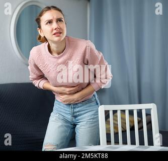 Junge Frau leidet Schmerzen im Unterleib Stockfoto