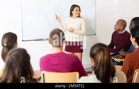 Wunderschöne junge Frau an der Universität vor dem Tafel Stockfoto