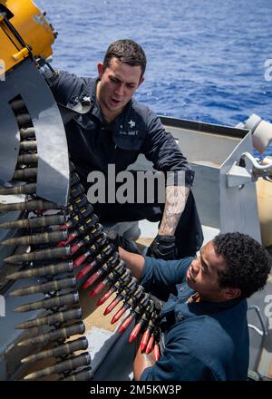 PHILIPPINE SEA (23. März 2022) Fire Controlman 1. Class Damian Castillosakihara, Left, aus Bayamon, Puerto Rico, Und Fire Controlman 2. Class Eric Jordan aus 29 Palms, Kalifornien, lädt Runden in das Phalanx Close-in Weapon System (CIWS) für eine Live-Feuerübung an Bord des Arleigh Burke-Class Guided Missile Destroyer USS Dewey (DDG 105) hoch, während Routineeinsätze im Verantwortungsbereich der US-7.-Flotte durchgeführt werden. Dewey ist der Destroyer-Staffel (DESRON) 15 zugeteilt und unterstützt derzeit ein freies und offenes Indo-Pacific. CTF 71/DESRON 15 ist der größte Forward-Dispatch der Marine Stockfoto