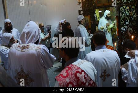 Koptische Priester bei der koptischen Kapelle auf der Rückseite der Ädikula in der Kirche des heiligen Grabes in Jerusalem. Stockfoto