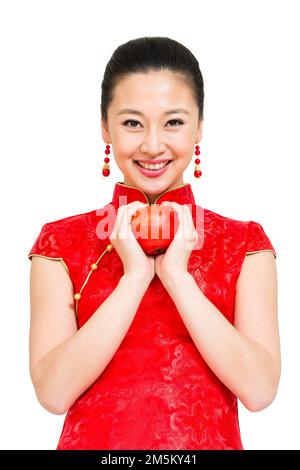 Die junge Frau von Cheongsam nahm den Apfel Stockfoto