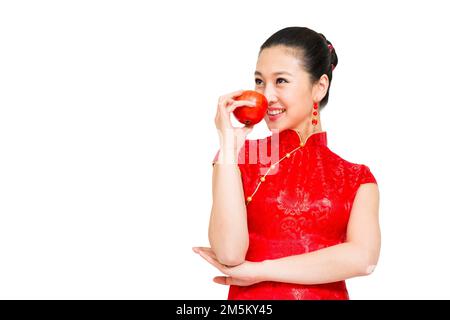 Die junge Frau von Cheongsam nahm den Apfel Stockfoto