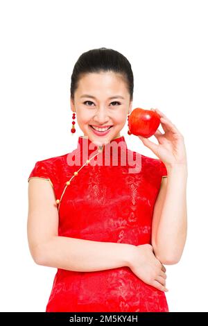 Die junge Frau von Cheongsam nahm den Apfel Stockfoto