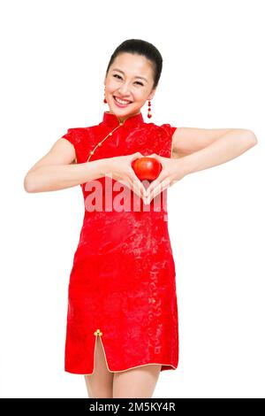 Die junge Frau von Cheongsam nahm den Apfel Stockfoto