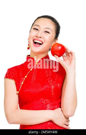 Die junge Frau von Cheongsam nahm den Apfel Stockfoto