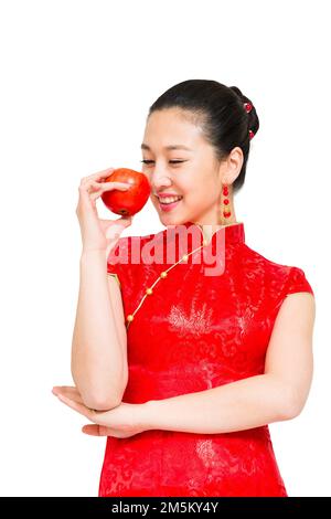 Die junge Frau von Cheongsam nahm den Apfel Stockfoto