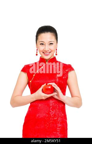 Die junge Frau von Cheongsam nahm den Apfel Stockfoto