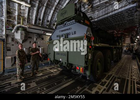 USA Air Force Tech. Sgt. Jennifer Drane (links), mit dem 16. Luftaufzug-Geschwader, und U.S. Marinekorps Staff Sergeant Thomas Ryan, mit Marine Wing Support Squadron 271, untersucht einen Terex-Demag Mac-50, nachdem er auf einen C-17 Globemaster III in Marine Corps Air Station Cherry Point, North Carolina, geladen wurde, 23. März 2022. Strategische Mobilitätsübung 22-1 verbesserte Einsatzbereitschaft der Mobilitäts- und Einschiffungskapazitäten der Einheiten in einem gemeinsamen Umfeld. Stockfoto