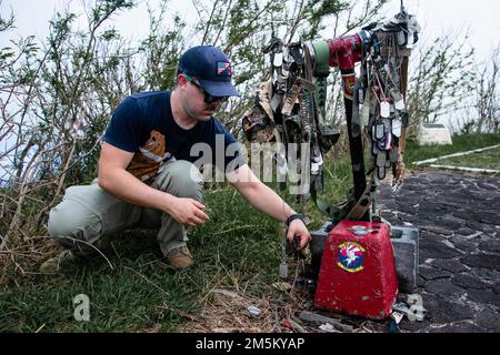 Ein Flugmann, der dem 18. Geschwader für Bauingenieure zugeteilt wurde, legt Erinnerungsstücke an einem Iwo Jima-Denkmal auf dem Gipfel des Mt. Suribachi in Iwo Jima, Japan, 23. März 2022. Marines und Airmen reisten nach Iwo Jima, um die Leben zu ehren, die während der Schlacht von Iwo Jima im Zweiten Weltkrieg verloren wurden Stockfoto