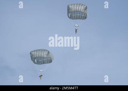 USA Fallschirmjäger des 4. Infanterie-Brigaden-Kampfteams (Airborne), 25. Infanteriedivision, USA Army Alaska, fliegen Sie über die Malemute Drop Zone während der Luftwaffeneinsätze auf der Joint Base Elmendorf-Richardson, Alaska, 24. März 2022. Die Fallschirmjäger führten das Training durch, um die Fähigkeiten zur Einsatzbereitschaft in einer arktischen Umgebung zu verbessern. Stockfoto