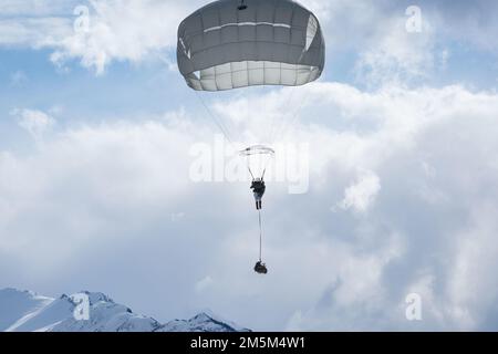 EIN US-AMERIKANISCHER Fallschirmjäger der Armee, dem 4. Infanterie-Brigaden-Kampfteam (Airborne), 25. Infanterie-Division, USA Army Alaska, fährt über der Malemute Drop Zone während der Luftwaffeneinsätze auf der Joint Base Elmendorf-Richardson, Alaska, 24. März 2022. Die Fallschirmjäger führten das Training durch, um die Fähigkeiten zur Einsatzbereitschaft in einer arktischen Umgebung zu verbessern. Stockfoto