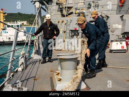 OKINAWA, Japan (24. März 2022) Seeleute an Bord der Arleigh-Burke-Klasse-Guided-Missile Destroyer USS Ralph Johnson (DDG 114) ziehen eine Leine. Ralph Johnson ist der Task Force 71/Destroyer Squadron (DESRON) 15, dem größten nach vorn verlegten DESRON der Marine, und der Hauptstreitkraft der US-7.-Flotte zugewiesen. Stockfoto