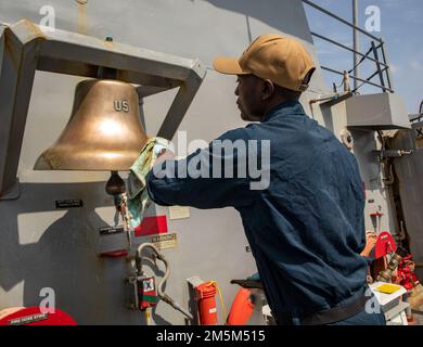 OKINAWA, Japan (24. März 2022) Spezialist für Feinschmecker der 2. Klasse Tyrie Mordecai aus Savannah, Georgia, strahlt die Glocke des Schiffes an Bord des Arleigh-Burke-Klasse-Zerstörers USS Ralph Johnson (DDG 114). Ralph Johnson ist der Task Force 71/Destroyer Squadron (DESRON) 15, dem größten nach vorn verlegten DESRON der Marine, und der Hauptstreitkraft der US-7.-Flotte zugewiesen. Stockfoto