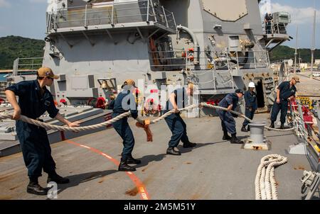 OKINAWA, Japan (24. März 2022) Seeleute an Bord der Arleigh-Burke-Klasse-Guided-Missile Destroyer USS Ralph Johnson (DDG 114) ziehen eine Leine. Ralph Johnson ist der Task Force 71/Destroyer Squadron (DESRON) 15, dem größten nach vorn verlegten DESRON der Marine, und der Hauptstreitkraft der US-7.-Flotte zugewiesen. Stockfoto