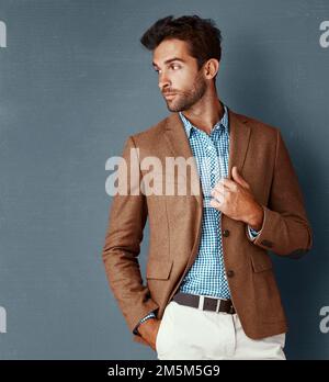 Bequem und dennoch stylisch. Studioaufnahme eines stilvoll gekleideten jungen Mannes, der vor grauem Hintergrund posiert. Stockfoto