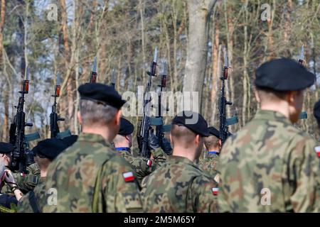 Polnische Soldaten feuern Platzpatronen während einer Gedenkveranstaltung in Zagan, Polen, am 24. März 2022. Militärangehörige verschiedener Nationen nahmen an der Gedenkfeier der sogenannten „Großen Flucht“ Teil, einem Fluchtversuch, der von Flugzeugen der britischen Royal Air Force aus einem deutschen Kriegsgefangenenlager in Zagan während des Zweiten Weltkriegs inszeniert wurde und mit der Hinrichtung von 50 zurückgekommenen Gefangenen endete. Stockfoto