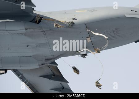 Fallschirmjäger der 4. Infanterie-Brigade-Kampfeinheit (Airborne), 25. Infanteriedivision, USA Army Alaska, springen Sie aus den USA Air Force C-17 Globemaster III über Malemute Drop Zone während des Flugtrainings auf der Joint Base Elmendorf-Richardson, Alaska, 24. März 2022. Armee- und Luftwaffeneinheiten bilden regelmäßig zusammen aus, um die Fähigkeit zur gemeinsamen Einsatzbereitschaft in einem arktischen Umfeld zu stärken und aufrechtzuerhalten. Flugzeuge aus dem 176. Flügel leisteten Luftunterstützung für das Training. Stockfoto