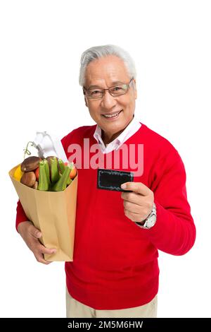 Ältere Männer mit einer Bankkarte in den Supermarkt werfen Stockfoto