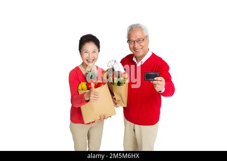 Ältere Paare mit einer Bankkarte in den Supermarkt einkaufen Stockfoto