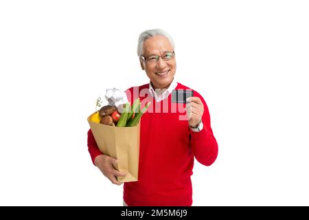 Ältere Männer mit einer Bankkarte in den Supermarkt werfen Stockfoto