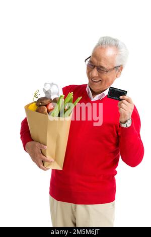 Ältere Männer mit einer Bankkarte in den Supermarkt werfen Stockfoto