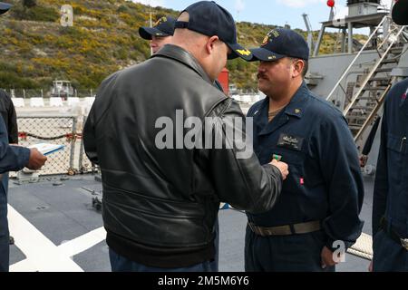 220204-N-UN585-2018 SOUDA BAY, Griechenland (24. März 2022) Cmdr. Scott Jones, kommandierender Offizier des Arleigh-Burke-Klasse-Guided-Raketen-Zerstörers USS Ross (DDG 71), Left, überreicht eine Navy and Marine Corps Achievement Medal an Chief Gunner's Mate Eduardo Soto, während das Schiff im Hafen in Souda Bay, Griechenland, am 24. März liegt. Ross, nach Rota, Spanien, ist auf seiner 12. Patrouille in den USA Sechster Einsatzbereich der Flotte zur Unterstützung regionaler Verbündeter und Partner sowie nationaler Sicherheitsinteressen der USA in Europa und Afrika. Stockfoto