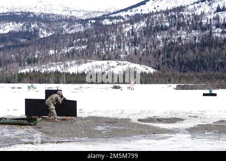 Ein Fallschirmjäger, zugewiesen zu Dog Company, 3. Bataillon, 509. Parachute Infanterie-Regiment, 4. Infanterie-Brigaden-Kampfteam (Airborne), 25. Infanterie-Division, USA Army Alaska, beteiligt sich am Stress-Feuertraining auf dem Sportfeuergelände auf der Joint Base Elmendorf-Richardson, Alaska, 24. März 2022. Die Soldaten der Dog Company wurden auf schnelle Feuerbereitschaft untersucht, während sie ein simuliertes Gefechtsfeldopfer sicher evakuierten, indem sie improvisierten Abfall von SKED und Kontakt über gefährlichen Schlamm und vereisten Boden brachen. (USA Air Force Photo/Justin Connaher) Stockfoto