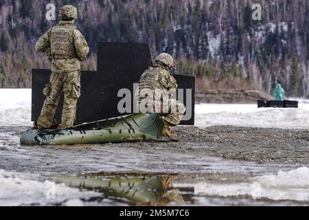 Ein Fallschirmjäger, zugewiesen zu Dog Company, 3. Bataillon, 509. Parachute Infanterie-Regiment, 4. Infanterie-Brigaden-Kampfteam (Airborne), 25. Infanterie-Division, USA Army Alaska, beteiligt sich am Stress-Feuertraining auf dem Sportfeuergelände auf der Joint Base Elmendorf-Richardson, Alaska, 24. März 2022. Die Soldaten der Dog Company wurden auf schnelle Feuerbereitschaft untersucht, während sie ein simuliertes Gefechtsfeldopfer sicher evakuierten, indem sie improvisierten Abfall von SKED und Kontakt über gefährlichen Schlamm und vereisten Boden brachen. (USA Air Force Photo/Justin Connaher) Stockfoto