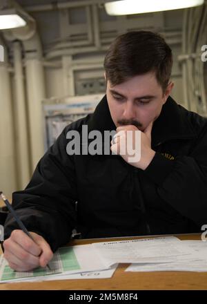 Master-at-Arms 3. Klasse Mike Lindsey aus Palm Beach, Florida, der der Sicherheitsabteilung von USS Gerald R. Ford (CVN 78) zugeteilt ist, nimmt an der Navy-weiten Aufstiegsprüfung für E-5-Kandidaten in Fords Hintergasse am 24. März 2022 Teil. Ford führt im Atlantik im Rahmen der auf das Schiff zugeschnittenen Grundphase vor dem Einsatz die Zertifizierung von Cockpits und die Qualifikation von Luftfahrtunternehmen durch. Stockfoto