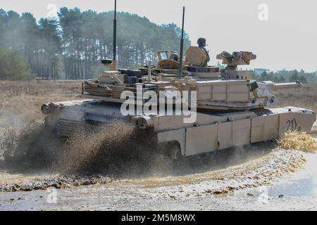 Ein M1A2-Abrams-Panzer wurde der Alpha-Kompanie zugeteilt, 2. Bataillon, 34. Rüstungsregiment, 1. Kampfteam der Brigade, 1. Infanteriedivision, fährt durch den Schlamm in Drawsko Pomorskie, Polen, 24. März 2022. Die Ausbildung des Fahrers diente dazu, die für die Bedienung der Fahrzeuge erforderlichen Fähigkeiten und das Vertrauen der Fahrer zu stärken. Stockfoto