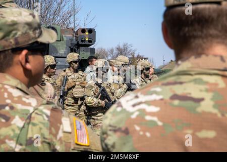 USA Soldaten der Armee sowie NATO-Verbündete und -Partner erhalten am 24. März 2022 vor der statischen Ausstellung des Waffenaustauschs auf dem Luftwaffenstützpunkt Mihail Kogalniceanu, Rumänien, eine kurze Einweisung. USA Die an der statischen Ausstellung des Waffenaustauschs beteiligten Armeesoldaten sind Teil des V-Korps, des US-Forward Disponated Corps in Europa, das mit den NATO-Alliierten und regionalen Sicherheitspartnern zusammenarbeitet, um Kampfeinsatzkräfte bereitzustellen, gemeinsame und multinationale Ausbildungsübungen durchzuführen. Und behält das Kommando und die Kontrolle über alle Rotations- und zugeteilten Einheiten im europäischen Theater, wie die 1. Infanteriedivision, 2. ca. Stockfoto