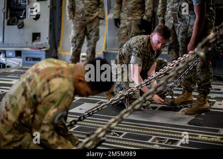 U.S. Airman 1. Class Isaiah Johnson (links), ein Ladeführer mit 16. Airlift-Geschwader und U.S. Cody Hull, Spezialist für Landungen bei 1. Marine Logistics Group, sichert ein Rettungs- und Feuerwehrfahrzeug der P-19R in einem C-17 Globemaster III während der strategischen Mobilitätsübung (STRATMOBEX) 22-1 an der Marine Corps Air Station Cherry Point, North Carolina, 24. März 2022. STRATMOBEX 22-1 verbesserte die Einsatzbereitschaft der Mobilitäts- und Einschiffungskapazitäten der Einheiten in einem gemeinsamen Umfeld. Stockfoto