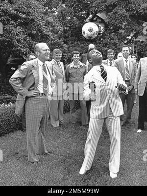 Das Dateifoto vom 28. Juni 1975 zeigt die brasilianische Fußballgrosse Pele versucht, einen Fußball auf seinem Kopf auszubalancieren, während er und US-Präsident Gerald R. Ford und die beiden einen Fußball um den Rosengarten des Weißen Hauses in Washington, DC, USA hüpfen. Pele, die brasilianische Fußballlegende, die drei Weltmeisterschaften gewann und zur ersten globalen Sportlegende wurde, ist im Alter von 82 Jahren gestorben. Pele wurde Ende November wegen einer Atemwegsinfektion und Komplikationen im Zusammenhang mit Darmkrebs in ein Krankenhaus in Sao Paulo eingeliefert. Letzte Woche sagte das Krankenhaus, dass sich sein Gesundheitszustand verschlechtert hatte, als sein Krebs fortschreitete. Er hat Stockfoto