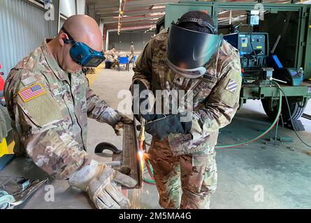 Zwei Soldaten aus dem Grundausrüstungsladen, Bravo Company, 87. Division Sustainment Support Battalion, 3. Infanterie Division Sustainment Brigade, fertigen eine Halterung für einen Generator am Zutendaal-Bauplatz in Beligium, März 23. Die Soldier-Mechaniker werden aus Fort Stewart, Georgia, nach Europa entsandt, um das Feldeinsatzbataillon der Armee Benelux, 405. Armee-Feldeinsatzbrigade, zu unterstützen, auf dem von der Armee vorbereiteten Lagerplatz von Aktien-2 in Zutendaal, Belgien. Stockfoto