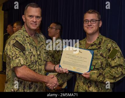 220325-N-EJ241-1010 DIEGO GARCIA, Britisches Territorium im Indischen Ozean (25. März 2022) – Master-at-Arms 2. Klasse Jordan M. Taylor, der Naval Support Facility (NSF) Diego Garcia zugewiesen, erhält während der Auszeichnungen im Quartier eine Navy and Marine Corps Achievement Medal von Kapitän Richard D. Payne, kommandierender Offizier der NSF Diego Garcia. NSF Diego Garcia bietet Logistik-, Service-, Freizeit- und administrative Unterstützung für US-Streitkräfte und Alliierte, die im Indischen Ozean und am Arabischen Golf stationiert sind. Stockfoto