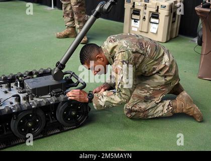 Airman 1. Class Dandre Goodson, ein EOD-Techniker (Explosive Ordinance Disposal), passt die Bedienelemente eines EOD-Roboters beim ERSTEN Robotics Regional Competition in Cedar Falls, Iowa (für Inspiration und Anerkennung von Wissenschaft und Technologie) an, 23. März 2022. Goodson demonstrierte, wie die Air Force bei ihrer täglichen Arbeit ähnliche Robotertechnologien wie die Roboter der Schüler einsetzt, um die Mission zu unterstützen. Stockfoto