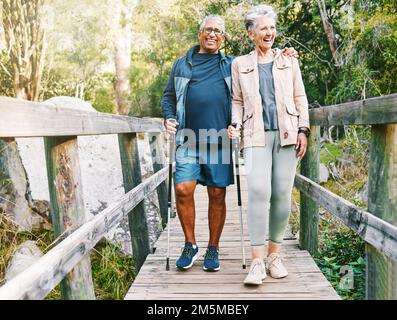 Entspannen Sie sich, Senioren oder ein paar Freunde wandern, wandern oder wandern Sie für Freiheit, Training oder Fitness im Naturwald. Rasse, Reise oder glückliche Frau Stockfoto