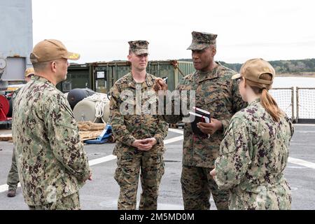 USA Marinekorps LT. General Michael E. Langley (Mitte rechts), Kommandeur der Flotten Marine Force, Atlantic (FMFLANT), Marine Forces Command (MARFORCOM), Marine Forces Northern Command (MARFOR NORTHCOM) und LT. Colonel Brian Jaquith sprechen mit den USA Marineblau Hinten. ADM. John V. Menoni (links), Kommandeur der Expeditionary Strike Group 2 (ESG-2) und Commander. Elizabeth A Nelson (rechts), befehlshabende Offizierin des Landungsschiffs Gunston Hall (LSD 44) der Whidbey Island-Klasse am 25. März 2022. Lieutenant General Langley besichtigte die Gunston Hall vor einem regulären Einsatz. Das Schiff ist eines der drei Kear Stockfoto